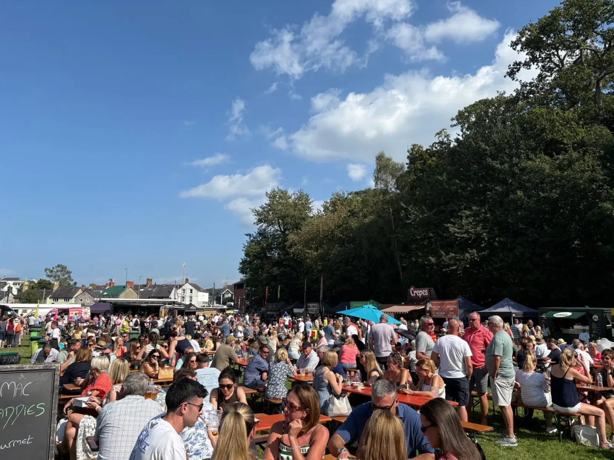People enjoying food in the sunshine at the Menai Food Festival. Anglesey summer events.