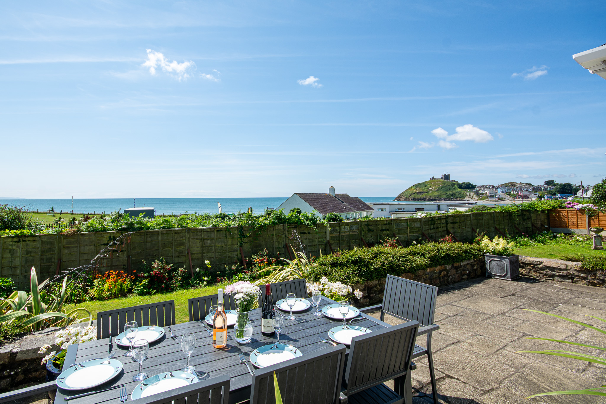 Holiday cottages in Criccieth, Llyn Peninsula. Dinner and wine on terrace with sea views out to Criccieth Castle.
