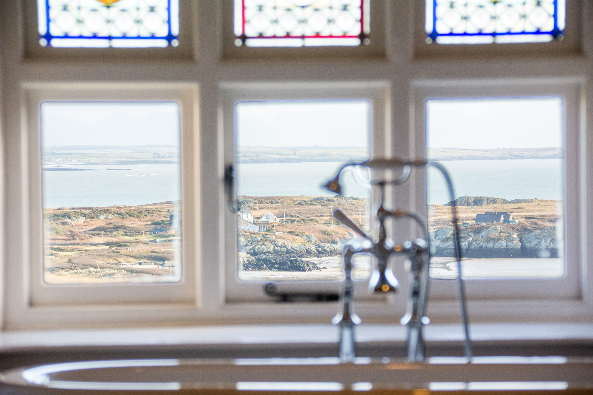 Sea-view through bathroom window of Rhoscolyn Beach at Plas holiday cottage on Rhoscolyn Headland in Anglesey