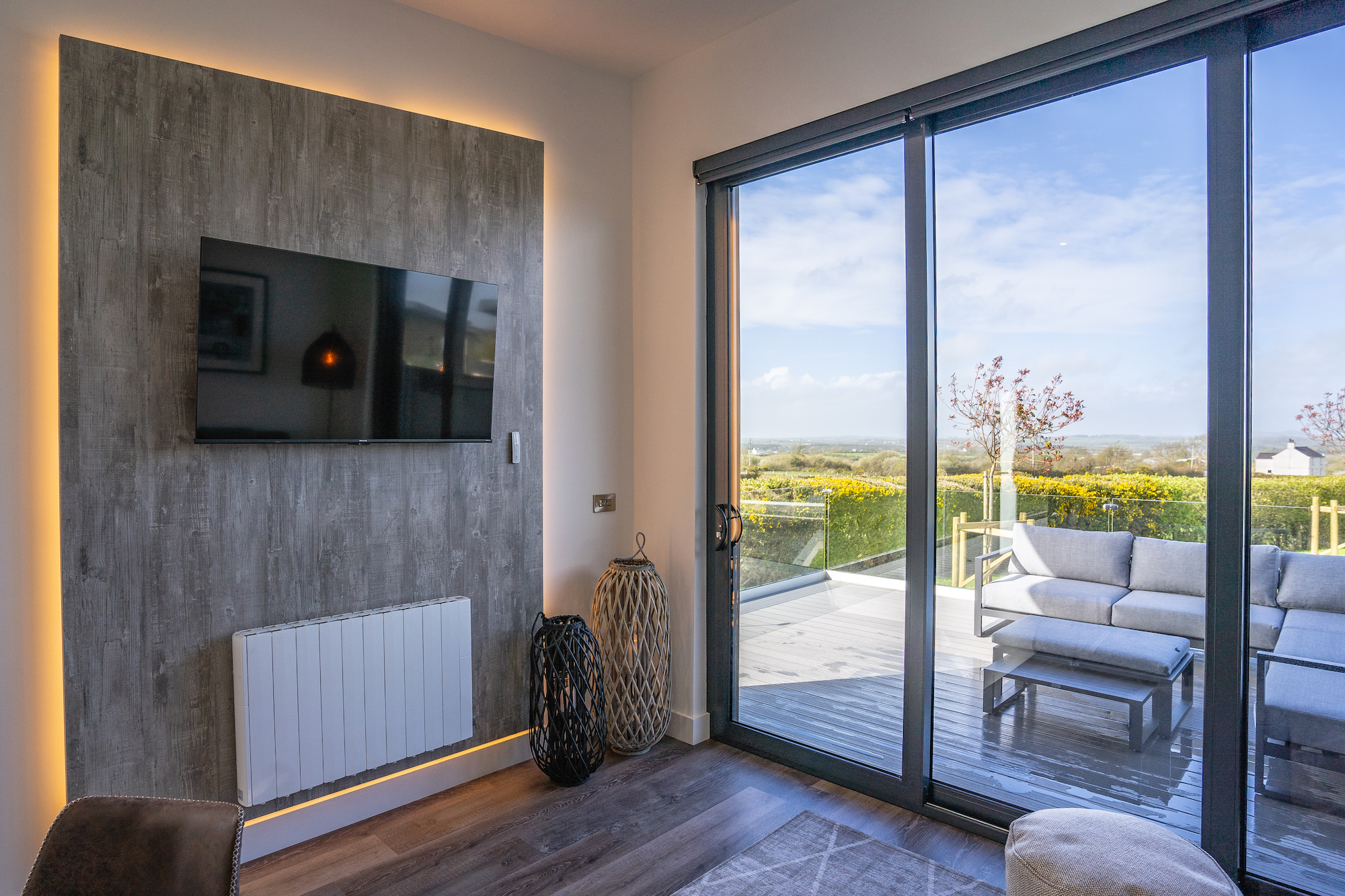 Modern living room with views across the terrace and countryside at Ty Llwyd Lodges in Rhostrehwfa, Llangefni