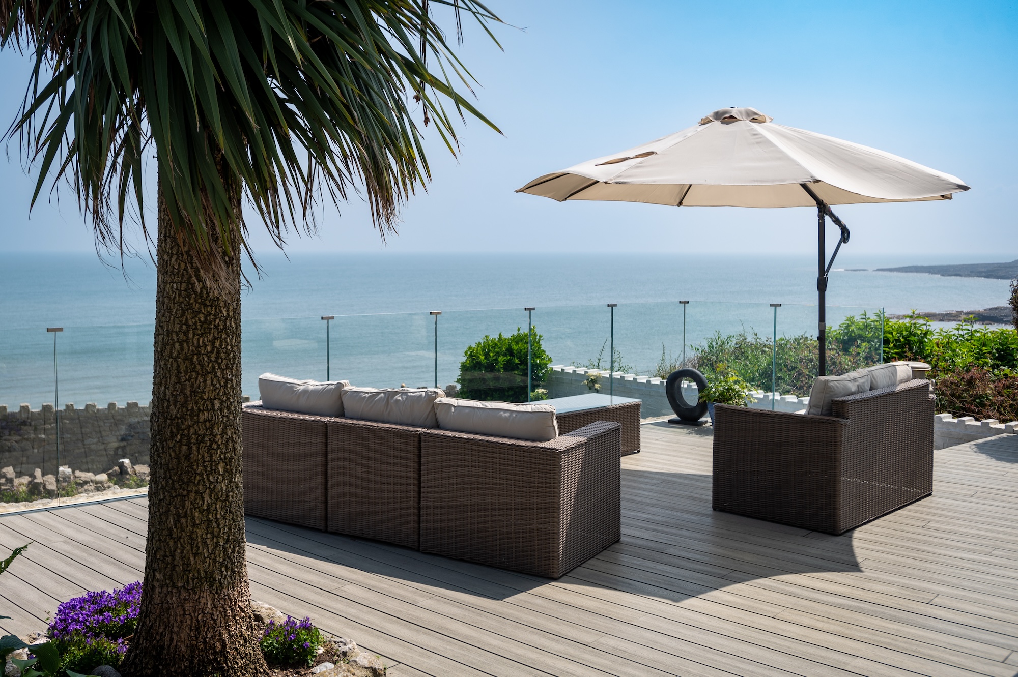 Glass balcony of Sea Spray holiday cottage on the headland overlooking the sea in Moelfre.