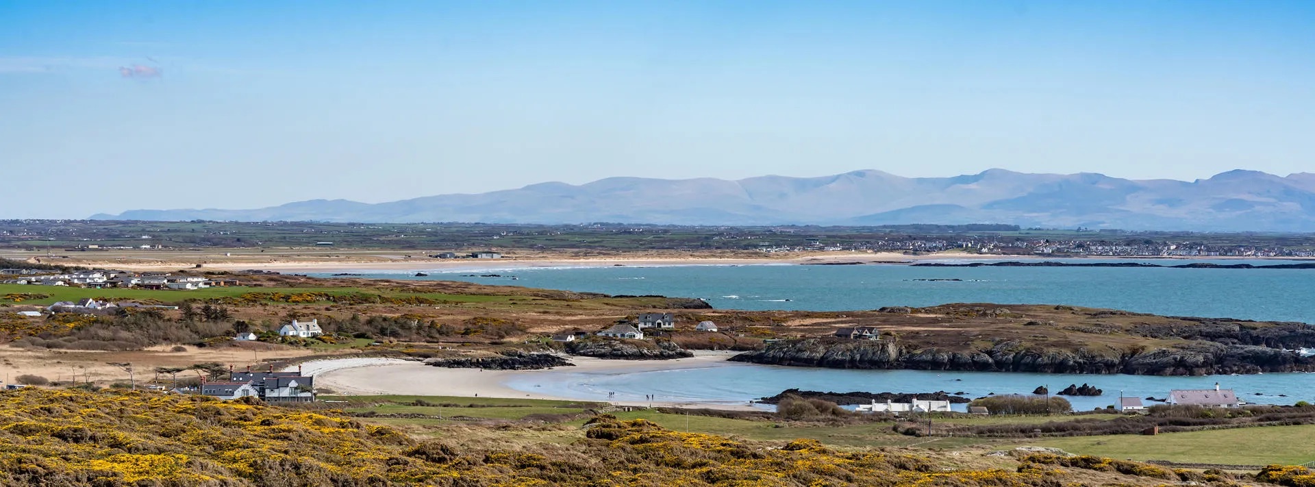 Aerial view across Rhoscolyn headland and beach. Holiday cottages in Rhoscolyn.