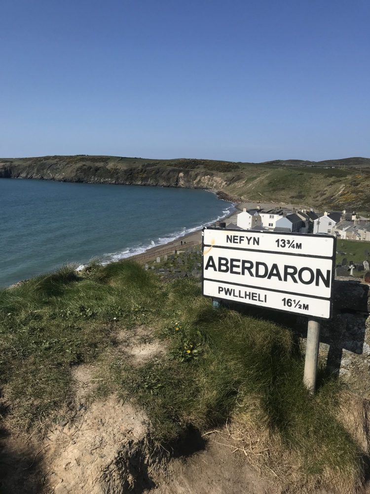 Aberdaron beach and village on the tip of the Llyn Peninsula, North Wales, with iconic town sign in the foreground