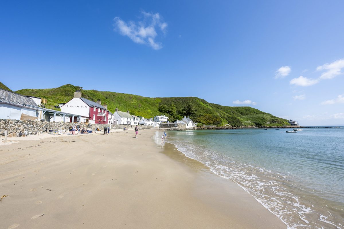 Nefyn beach on the Llyn Peninsula, North Wales, with a sweeping bay of calm blue water and golden sand