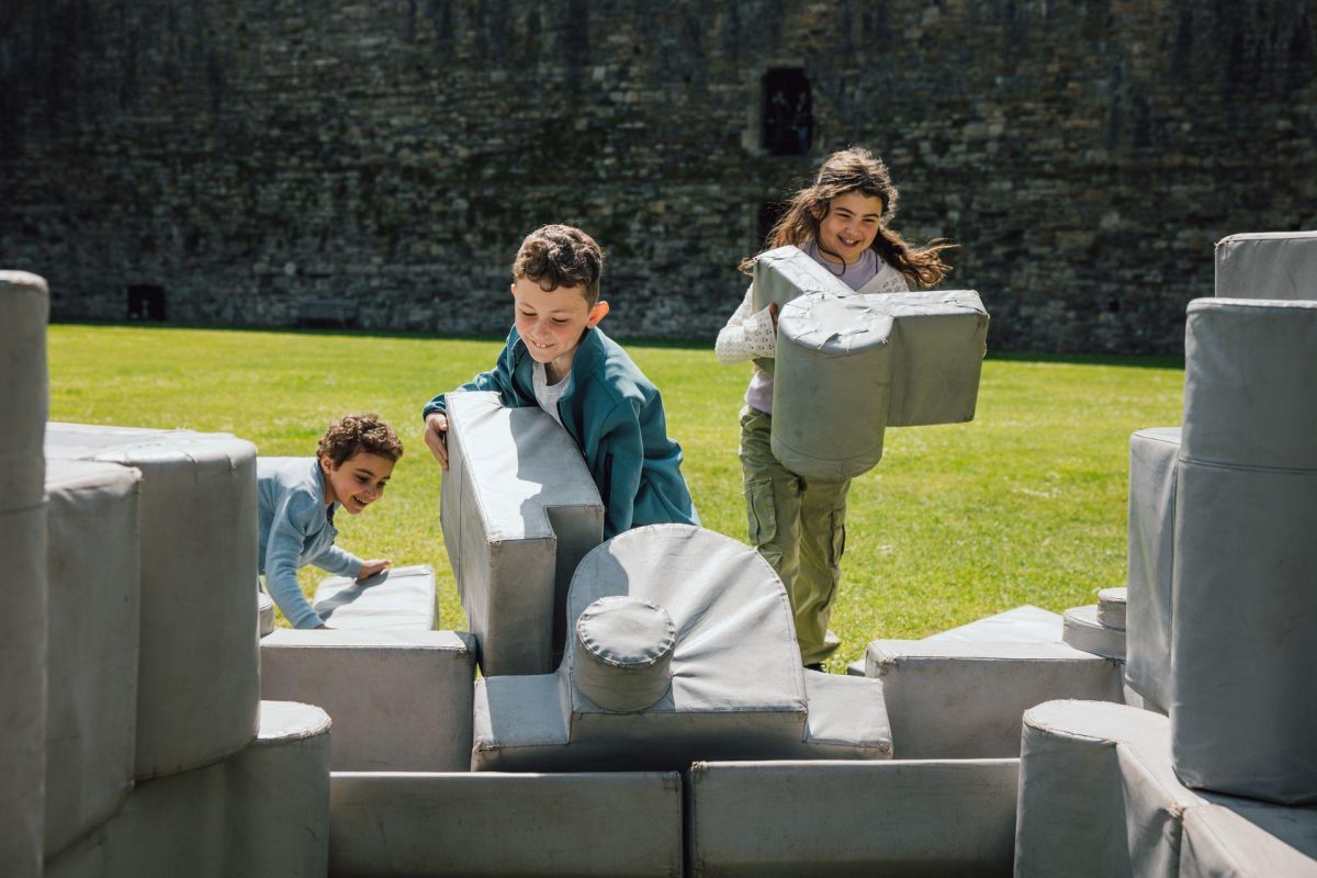 things to do with kids in North Wales - children playing with foam building blocks outside Beaumaris castle Anglesey