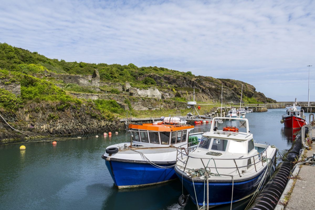 Amlwch Port on the Isle of Anglesey coast path with fishing boats and ruined stone buildings