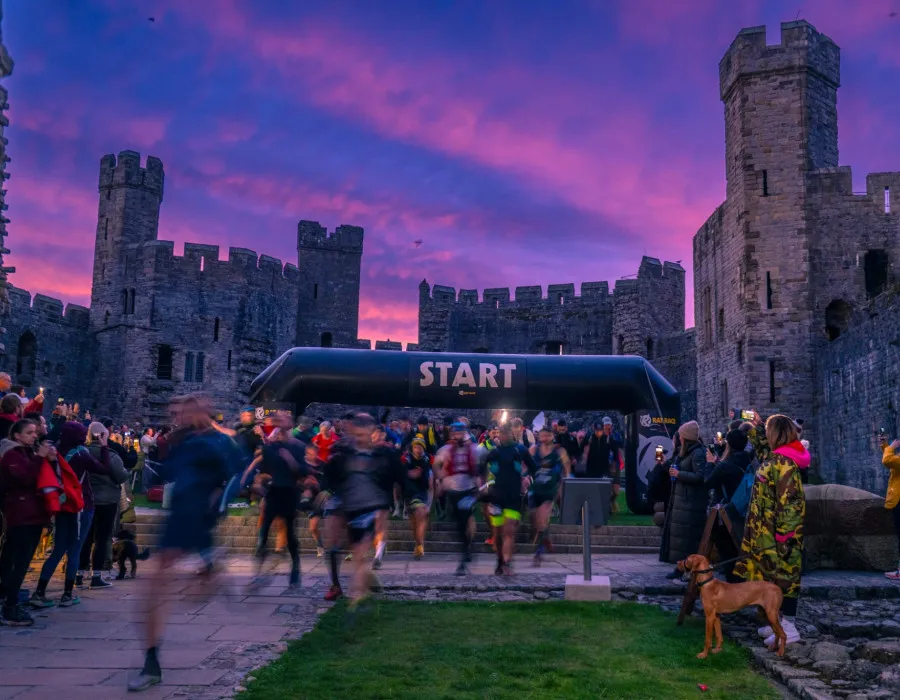 An early morning picture of racers departing a start line at Caernarfon Castle