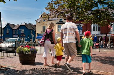 A family walking through Pwllheli's town centre and shopping hub