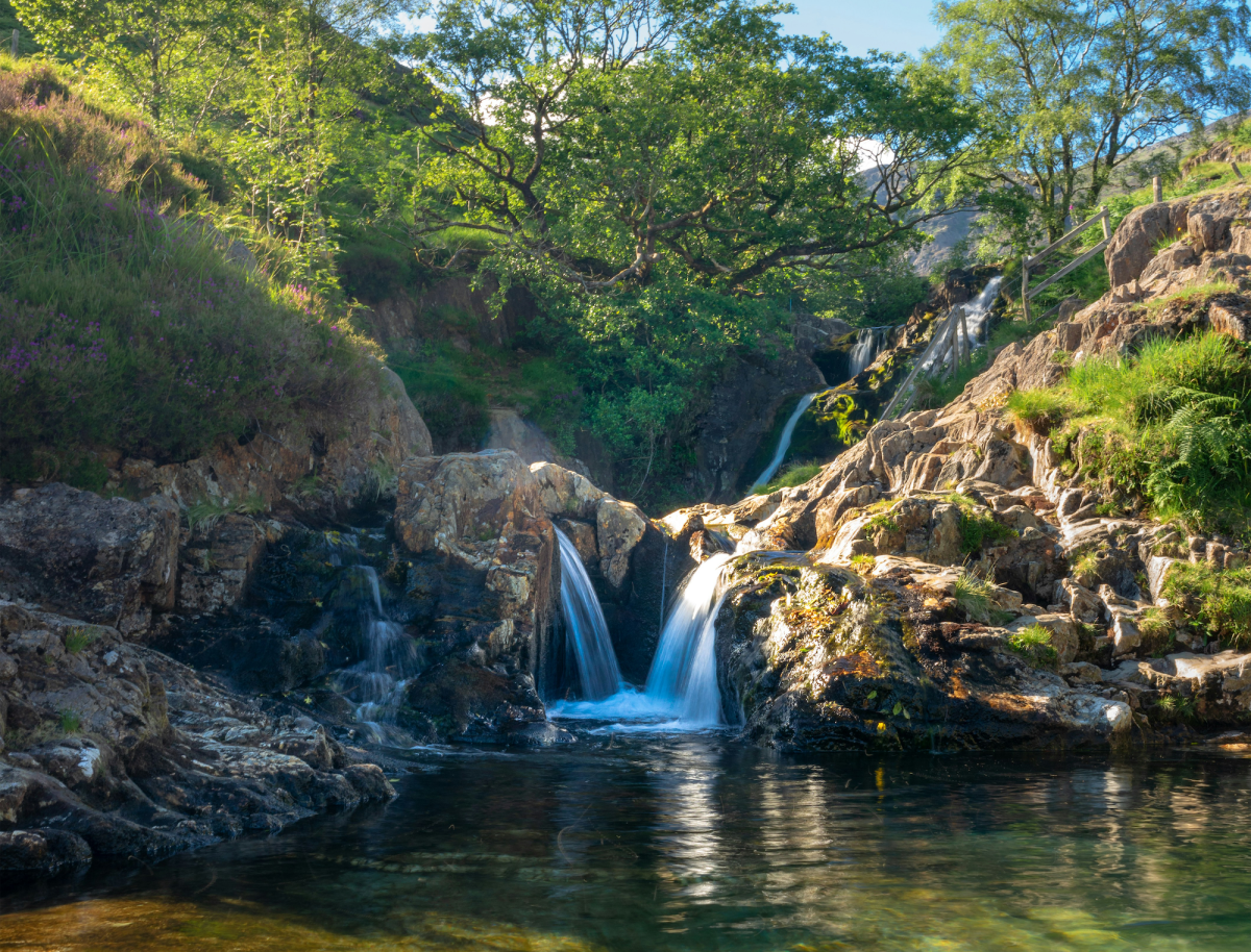 a summery picture of the stunning Watkin Path pools in Snowdonia with a small waterfall in the background
