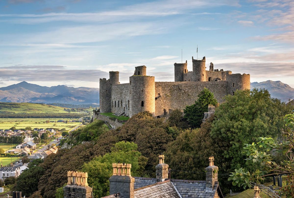 A serene image of Harlech Castle in North Wales with the mountains behind it